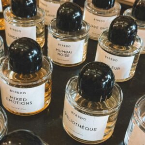 Close-up view of various Byredo perfumes with elegant labels arranged on a shelf.